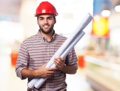 homme souriant, coiffé d’un casque rouge et portant deux plans.